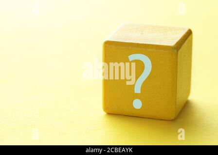 Wooden yellow block on yellow gradient background with question mark, concept of analysis, research and finding a solution.