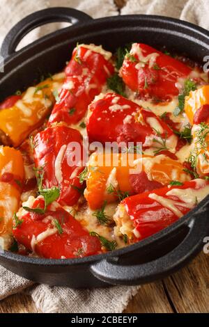 Stuffed peppers with rice and meat baked with cheese and tomatoes close-up in a pan on the table. vertical Stock Photo