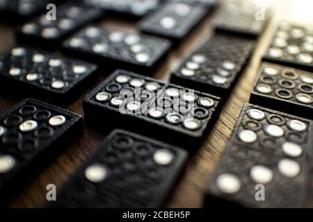 Selective focus shot of black dominos on a wooden table Stock Photo