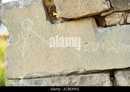 Ancient petroglyphs on the stone walls of an old house Stock Photo