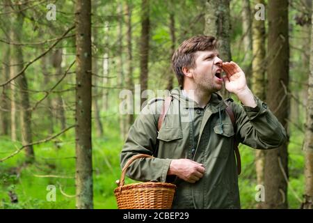 Old man gathers mushrooms showing a cep from basket. Stock Photo