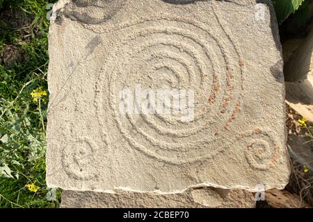 Ancient petroglyphs on the stone walls of an old house Stock Photo