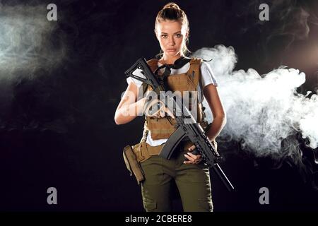 Woman in the army pros and cons. Women do not just serve, but attain high positions and ranks. Beautiful woman in military outfitholding weapon in han Stock Photo