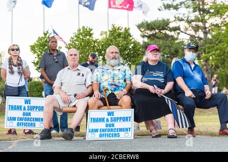 A group of older people, only one wearing a mask, sitting at a Back the Blue Rally to support local police and oppose the new police reform bill. Stock Photo