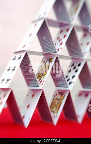 A close up of a pyramid shaped house of cards A close up of a pyramid shaped house of cards