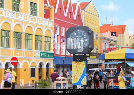 WILLEMSTAD, CURACAO - FEBRUARY 11, 2014: Colorful waterfront buildings and a clock in Willemstad historic district Punda on Curacao island. The city c Stock Photo