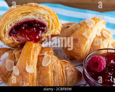 Yummy freshly croissant, with raspberries jam filling cut, close up Stock Photo