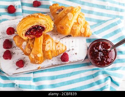 Yummy freshly croissant, with raspberries jam filling cut, close up Stock Photo