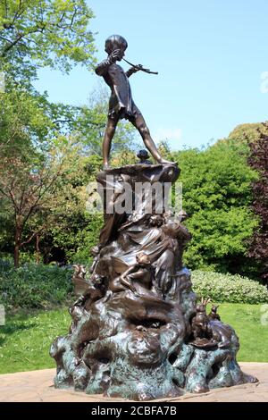 Peter Pan statue sculpture in Kensington Park Gardens London England UK unveiled in 1912 which is a popular travel destination tourist attraction land Stock Photo