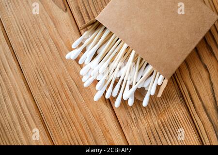 Cotton buds made of wood. Eco-friendly cotton ear sticks. Wood background. Stock Photo