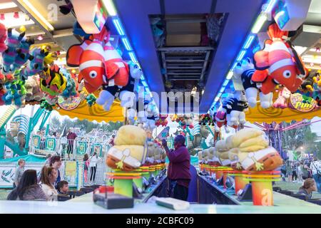 A worker awards a stuffed animal to visitor playing a game at the Wyoming State Fair in Douglas on Wednesday, August 12, 2020. The 108th annual fair opened this week with additional precautions to prevent the spread of the COVID-19 virus. Stock Photo