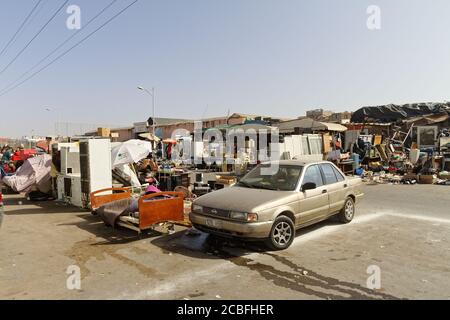 Meknes, Morocco, Feb,7,2019,Street fleemarket on sidewalk, blue sky with old covered sales hall. People try to sell second-hand and everyday household Stock Photo