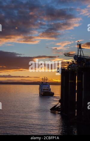 INVERGORDON, SCOTLAND - 2016 MARCH 09. Offshore vessel doing a rig move at sunset at Cromarty Firth Scotland. Stock Photo