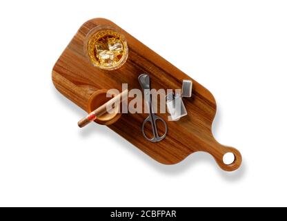 Isolated shot of a crystal glass and decanter full of golden whisky, cigar, cigar cutter and petrol lighter on a wooden serving tray, shot from above Stock Photo