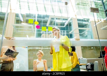 creative fair-haired woman and her employees using stickers at workplace. close up photo.start up business Stock Photo