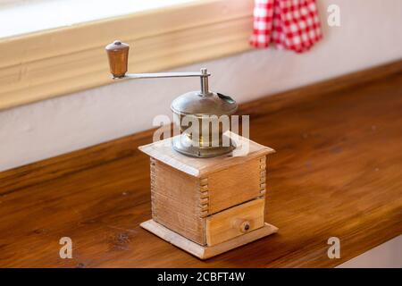 Vintage coffee grinder - old wooden manual coffee grinder in the kitchen Stock Photo