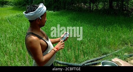 DISTRICT KATNI, INDIA - AUGUST 20, 2019: An indian village farmer operating phone concept for asian people digital learning concept. Stock Photo