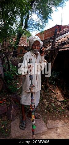 DISTRICT KATNI, INDIA - AUGUST 20, 2019: An indian village elderly traditional man operating phone, concept for asian people digital learning. Stock Photo