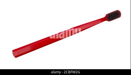 New red toothbrush with black hairs isolated on a white background Stock Photo