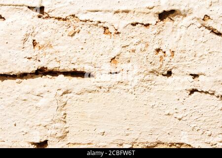 Texture of an old brick wall painted with white paint close-up. Stock Photo