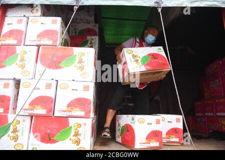 Beijing, China. 6th Aug, 2020. A merchant unloads apples in a temporary trading area at the Xinfadi wholesale market in Beijing, capital of China, Aug. 6, 2020. Credit: Zhang Chenlin/Xinhua/Alamy Live News Stock Photo