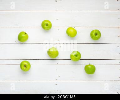 Several green apples on white wooden boards. Stock Photo