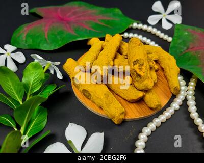 Turmeric, (Curcuma longa) with yellow flowers isolated on black background. Used as an herbal medicine for rheumatoid arthritis and antioxidant activi Stock Photo