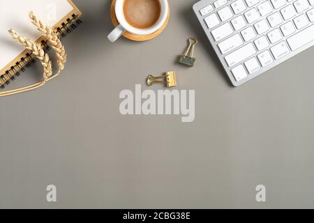 Frame of computer keyboard, cup of coffee, office stationery, paper note and wheat on green background. Top view, flat lay autumn style workspace. Stock Photo