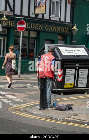 Homeless man selling Big Issue on street corner Kemptown, Brighton, East Sussex, UK. Stock Photo