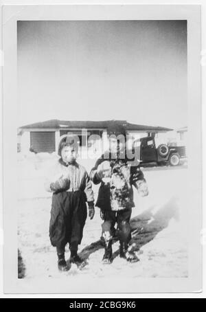 1957 vintage image of brother and sister playing in the snow, Colorado, USA Stock Photo