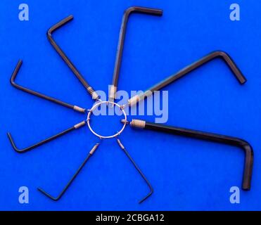 Closeup overhead shot of a varied size set of steel L-shaped, hex / allen keys, held together on a ring, evenly spread out in a circular pattern. Stock Photo