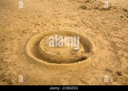 Small sand castle on moat on a beach Stock Photo