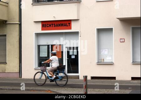 Symbolfoto: ein Radfahrer vor einer Anwaltskanzlei; Symbolic photo: a cyclist in front of a law firm; Stock Photo