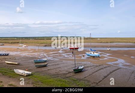 Small boats stranded on wet sand at low tide Stock Photo