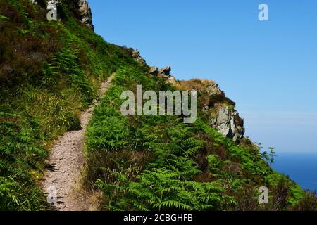 The coast path climbs steeply towards a rocky outcrop between Woody Bay and Heddon's Mouth on the North Devon coast. Stock Photo