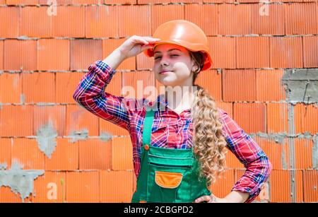 girl in helmet is construction worker. foreman teen child. kid work in the helmet. little girl in a helmet. girl making repairs. teen dressed in hard hat. concept of childhood development. Stock Photo