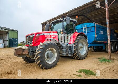 Massey Ferguson four wheel drive tractor and trailer parked under a lean to in a North Norfolk farmyard. Stock Photo