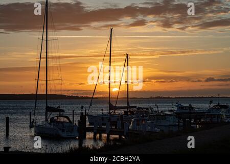 Hiddensee, Germany, 10-14-2019, Hiddensee Island in the Western Pomerania Lagoon Area/ sunrise on the bay with boats near port of Vitte Stock Photo