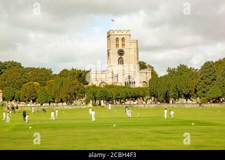 Junior youth cricket match on the picturesque church meadow the home of Thame cricket club Oxfordshire England with St Mary's church in the background Stock Photo