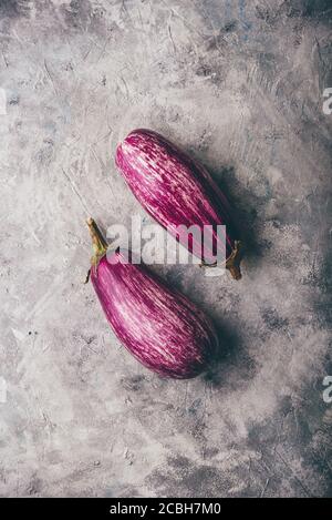 Two purple eggplants on concrete backdrop Stock Photo