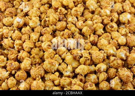 Delicious candy caramel covered popcorn close up snack food background Stock Photo