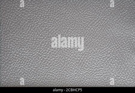 The texture of high-quality natural leather of dark color with a characteristic fine mesh pattern. Background. Stock Photo