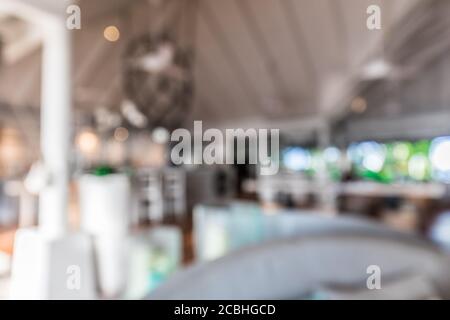Blurred image of cafe interior with wooden table in front. Abstract blur coffee shop Stock Photo