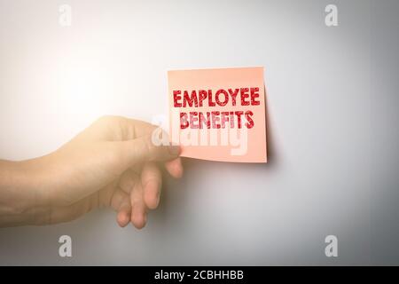 EMPLOYEE BENEFITS. Qualification, job offer, specialists and loyalty concept. Woman 's hand and sticky note Stock Photo
