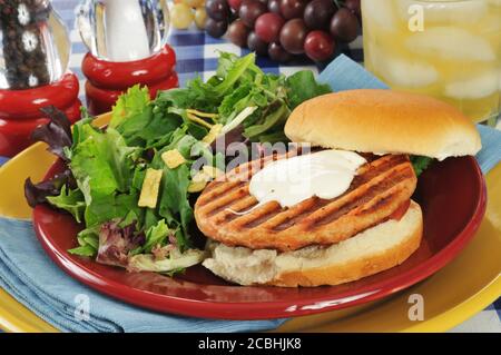 A grilled salmon burger with a green salad and lemonade Stock Photo