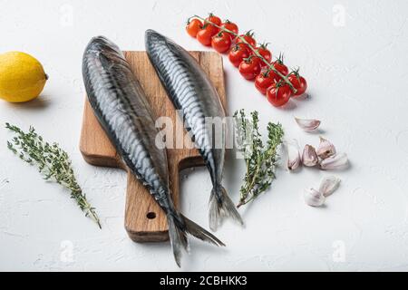 Two whole mackerel with ingredients on white textured background Stock Photo
