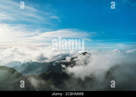 Beautiful view of mountain top in fog. Dramatic scene. Fantastic landscape of green mountain ranges. Stock Photo
