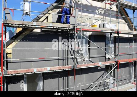 Construction workers insulates house facade Stock Photo