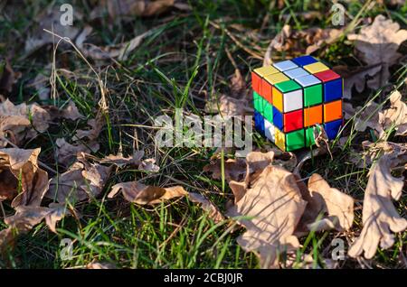 Kyiv, Ukraine - October 18, 2019. Rubik's cube Rubik's cube on grass and dry oak leaves in the rays of the setting sun Stock Photo