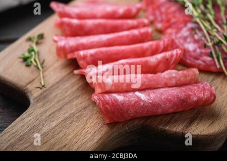 Salchichon dry cured sausages cut in slices on old wooden table Stock Photo